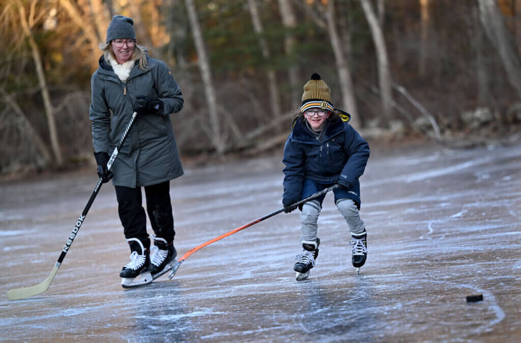 Harry Schoff, 8, of Carlisle, chases down the puck while playing hockey with his mother, Sarah Schoff, at Nick Macone Pond on Lowell Road, on Wednesday January 8, 2025. Ken McGagh/The Acton Bridge