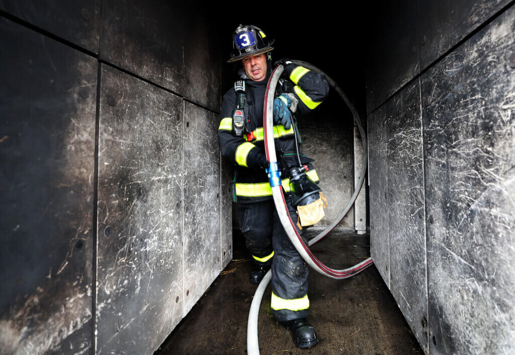 Acton firefighter Celso Nascimento carries fire house inside the Worcester Fire Department burn building during a “refresher” training session on Monday, September 27, 2026. Ken McGagh/The Acton Bridge
