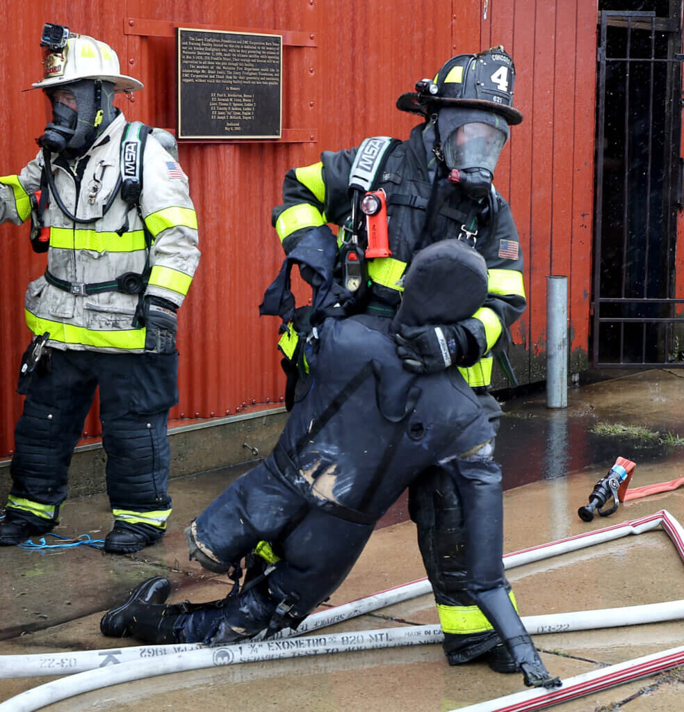 Acton firefighter Elsa Heil “rescues” a mannequin a during “refresher” training session at the Worcester Fire Department Training Center burn building on Monday, September 27, 2026. Ken McGagh/The Acton Bridge