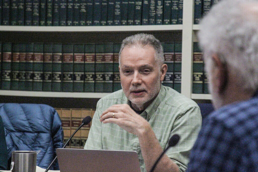 Select Board Chair Mark Howell speaks with colleague Paul Boehm during a January 12 meeting. Photo: Dakota Antelman/The Acton Bridge