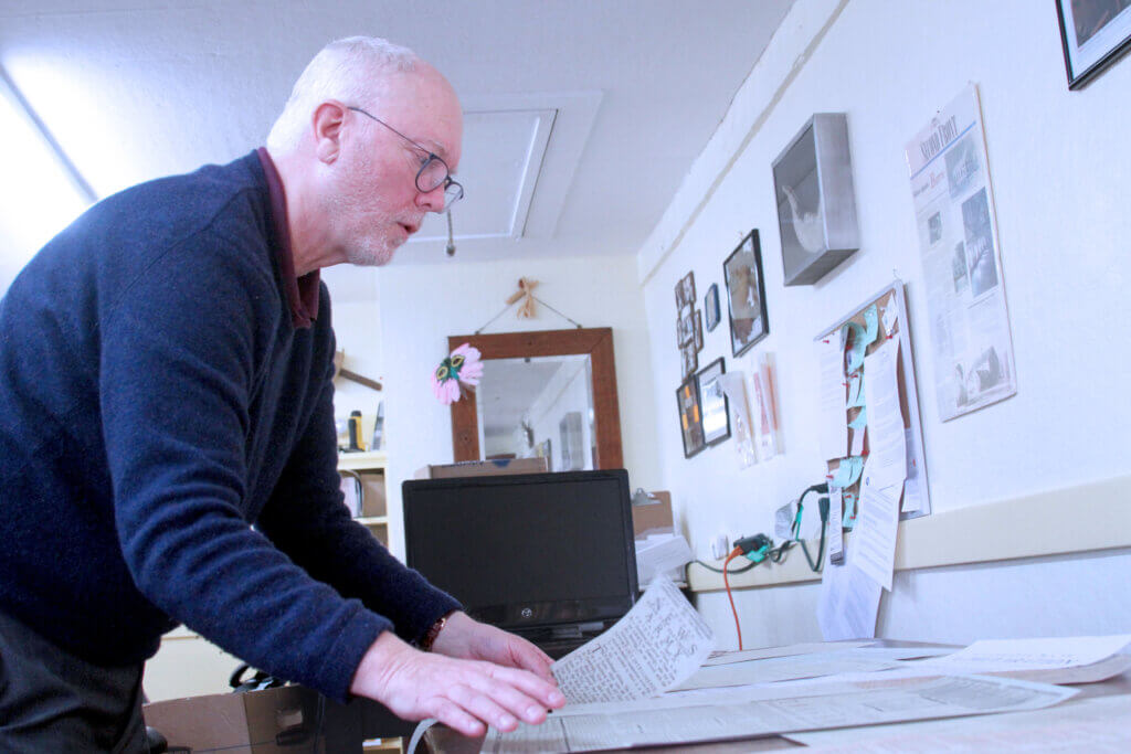 Acton Scout House board member David Owen lays out historic broadside flyers that the Scout House will display during Saturday’s Concord250 celebrations. Photo: Dakota Antelman/The Acton Bridge