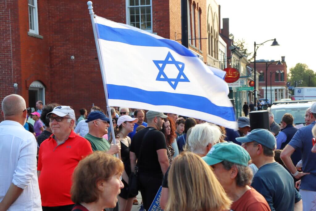 Some rallygoers flew Israeli flags over the crowd or wore them as capes. Photo: Trace Salzbrenner/The Acton Bridge