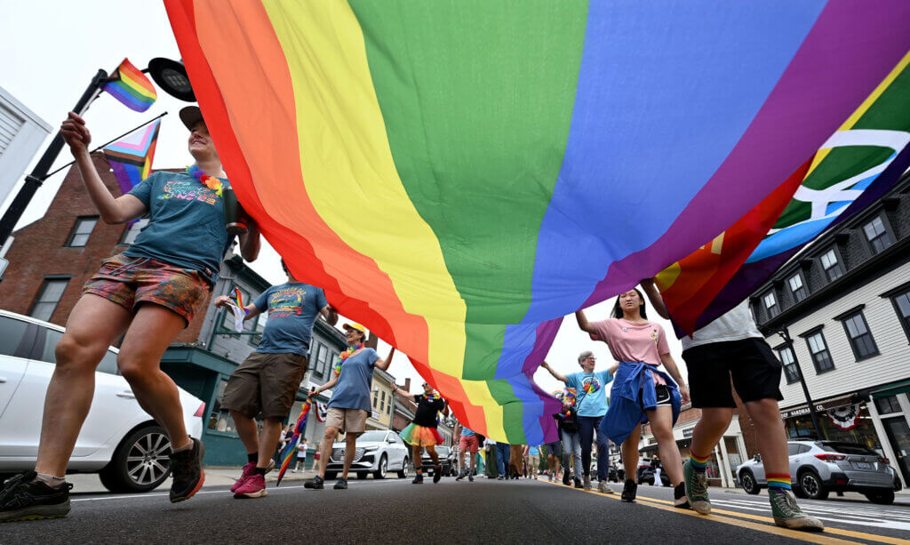 The rainbow flag fills Main Street as it is carried through Acton Center during  ConcordPride festivities on Saturday.

