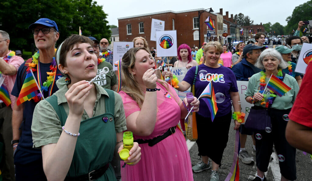 Members of the Acton Players blow bubbles in Acton Center during Pride celebrations.   
