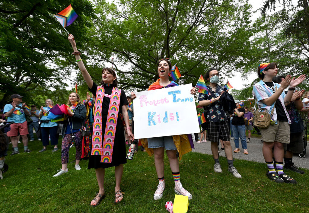 Maggie Stewart, center, a rising college senior from Acton, and Rev. Martha Schick of the Trinitarian Congregational Church particpate in the Monument Square Pride rally.
