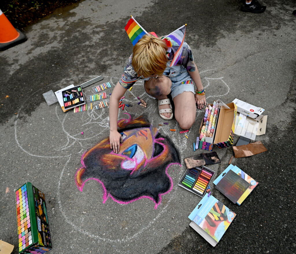 Chalk artist Kathryn Schmatlz works on a piece at the Umbrella Arts Center.
