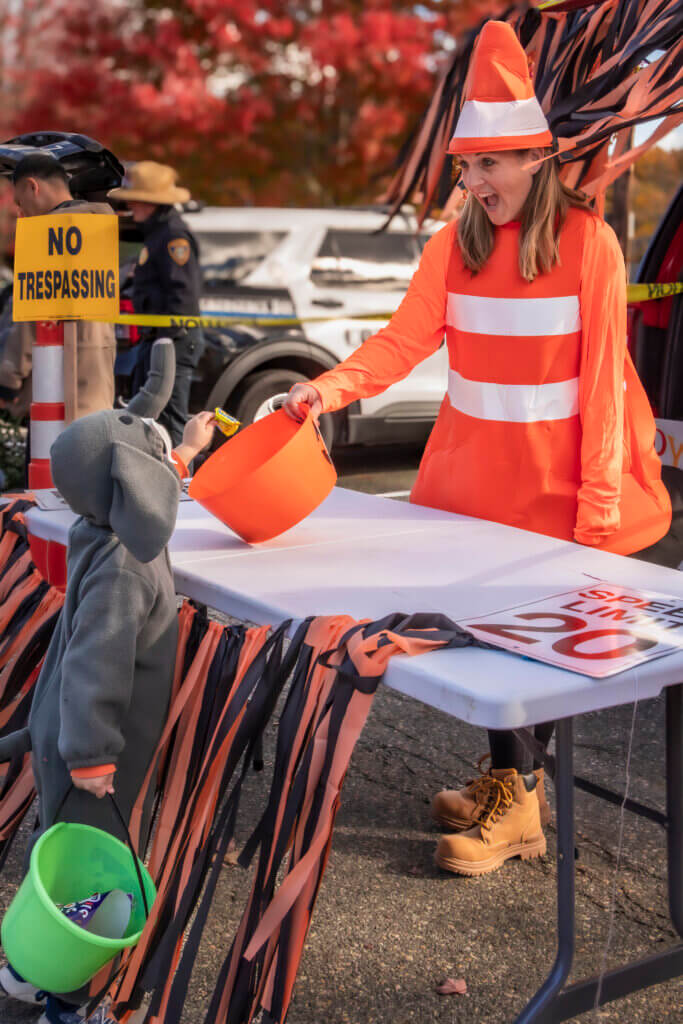Acton Fire Department Lt. Lindsay McGloughlin offers Halloween candy to a hungry elephant. Photo: Jean Fain/The Acton Bridge