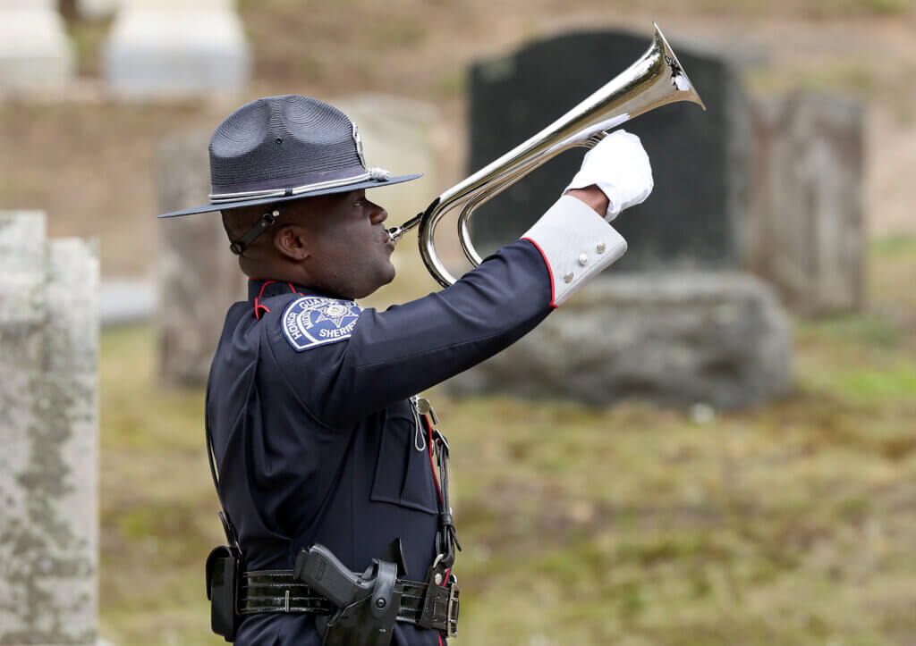 Sgt. Ducakis Germain of the Middlesex Sheriffi’s Office plays Taps during a flag placement ceremony in honor of slain Middlesex Jail Master David S. Robinson of Acton, who was killed while attempting to prevent an escape at the Middlesex Jail in Cambridge on Mother’s Day May 14, 1961, 65 years ago, at Sleepy Hollow Cemetery in Acton on Wednesday, April 29, 2026. Ken McGagh/The Acton Bridge