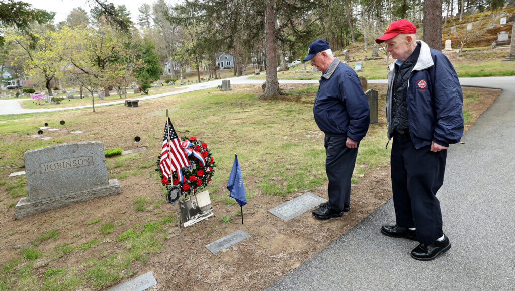 Acton resident Peter Robinson, 79, right, and his brother, Bob Robinson, 86, of Wells, Maine, stand at the grave of their uncle, David S. Robinson, after the Middlesex Sheriff’s Offfice’s flag placement ceremony in Jail Master Robinson’s honor, at Sleepy Hollow Cemetery in Acton on Wednesday, April 29, 2026. A native of Acton, Jail Master Robinson was killed while attempting to prevent an escape at the Middlesex Jail in Cambridge on Mother’s Day, May 14, 1961. Ken McGagh/The Acton Bridge
