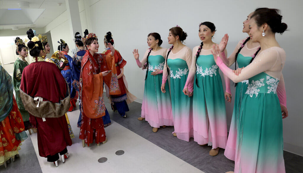 Coming of the Acton-Carlisle auditorium stage, the Yuanqi Ladies Team, left, greet WeDanceBoston, the next act, during the third annual Lunar New Year Celebration on Saturday, February 7, 2026. This year is the Year of the Horse. Ken McGagh/The Acton Bridge