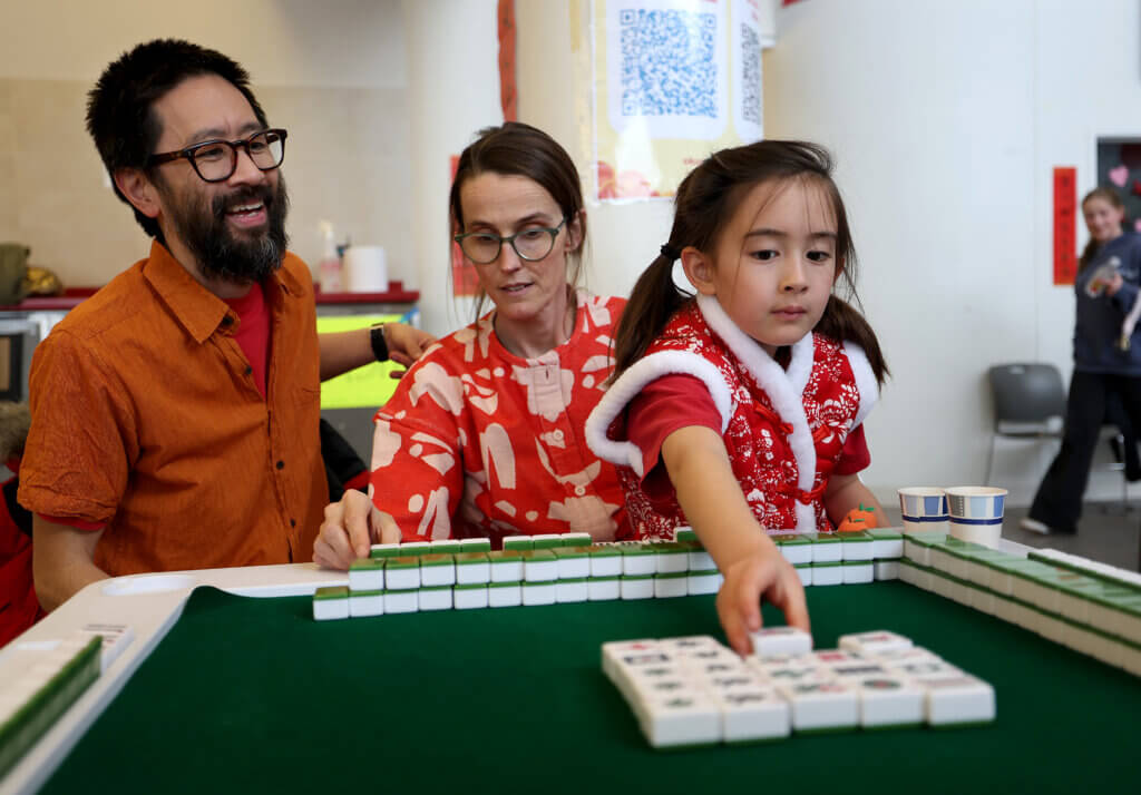 Bernadette Chen, 7, and her parents Brin and Alex Chen play Mahjong during the third annual Lunar New Year Celebration at Acton-Carlisle High School on Saturday, February 7, 2026. Ken McGagh/The Acton Bridge