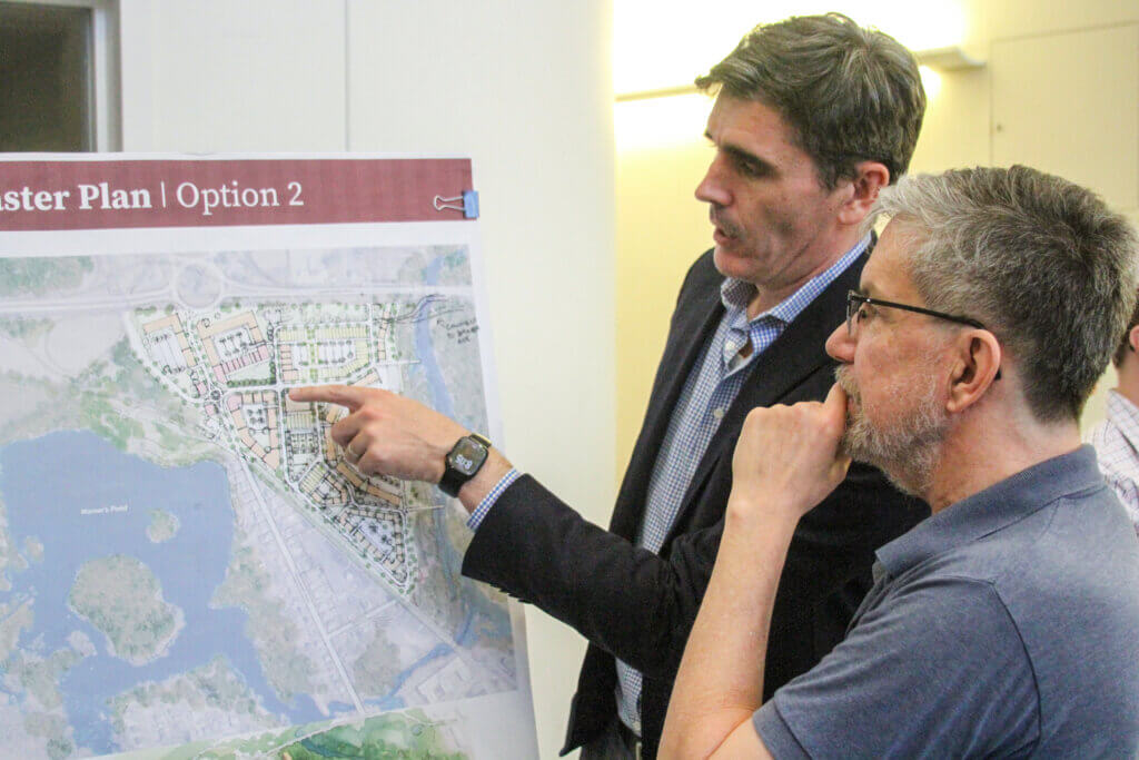 Concordian David Karr looks at a poster with Speck Dempsey consultant Chris Dempsey. Photo: Dakota Antelman/The Acton Bridge