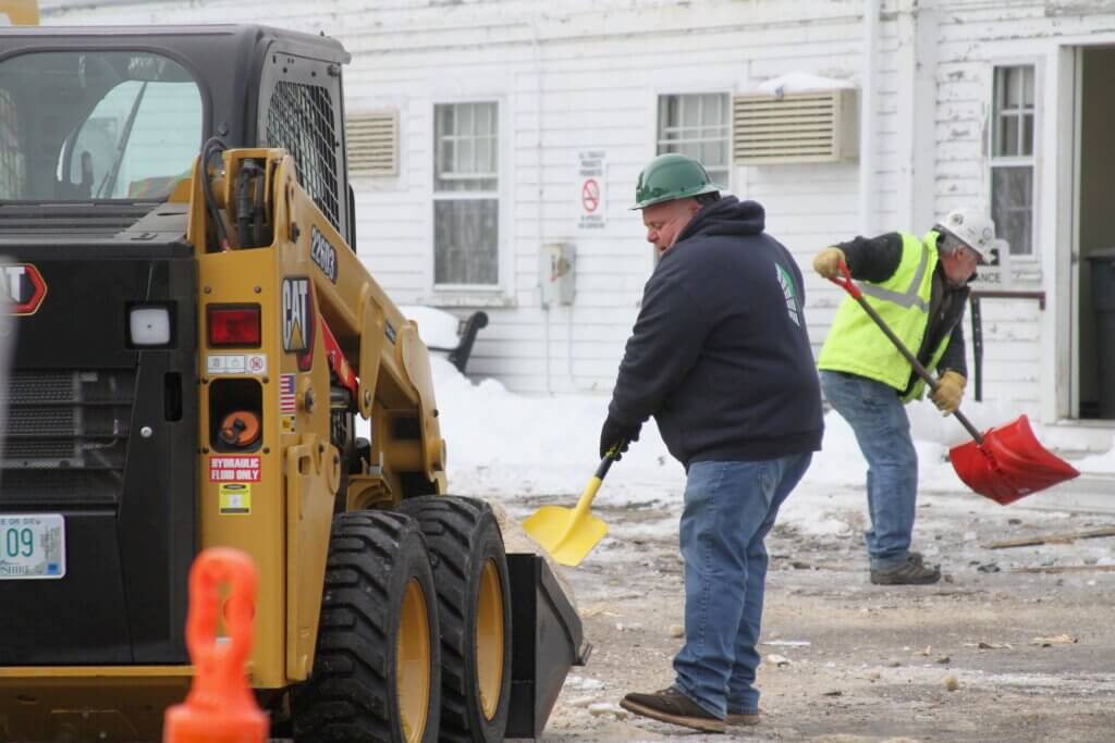 Workers pause their demolition to spread salt on the pavement for excavation equipment. Photo: Dakota Antelman/The Acton Bridge
