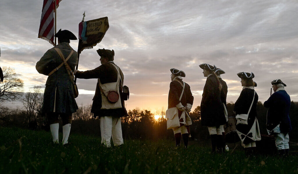 The Acton Minute Men seen against the sunrise, Patriots Day 2024. Photo: Ken McGagh/The Acton Bridge
