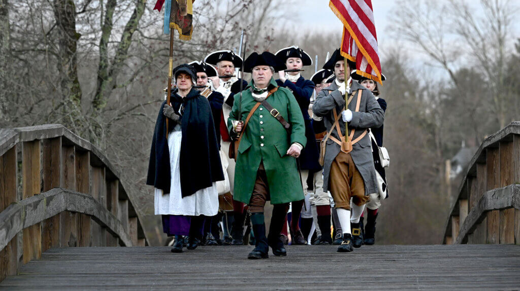 The Acton Minute Men march over Old North Bridge during the annual Dawn Salute, April 19, 2024.  Photo: Ken McGagh/The Acton Bridge