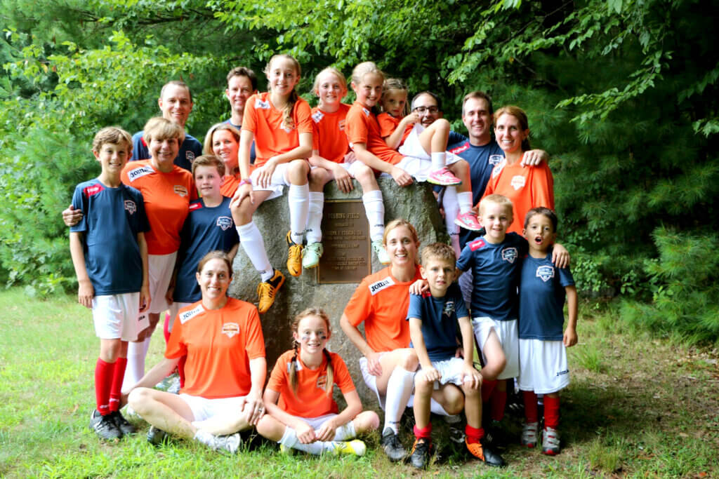 The Cushing family gathers near the entrance to the field named in honor of their patriarch. (Carole Cushing is in the second row, second from left). Courtesy photo