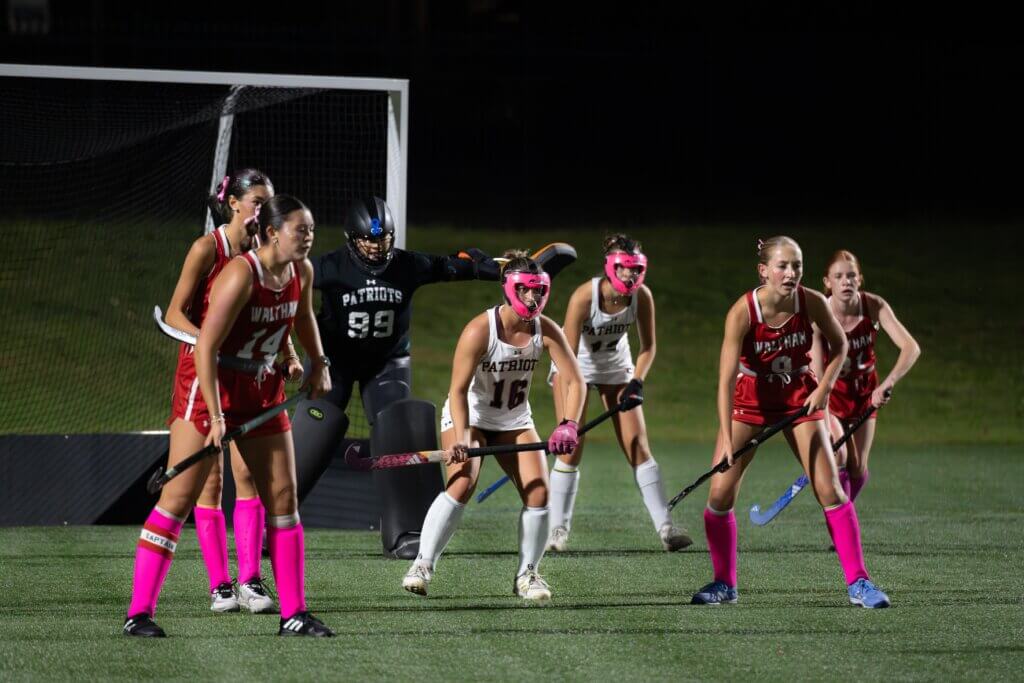 Goaltender Lexie Ramirez, Ally Couto, and Zoë Bonzagni prepare for a Waltham attack. Photo by David Clancy