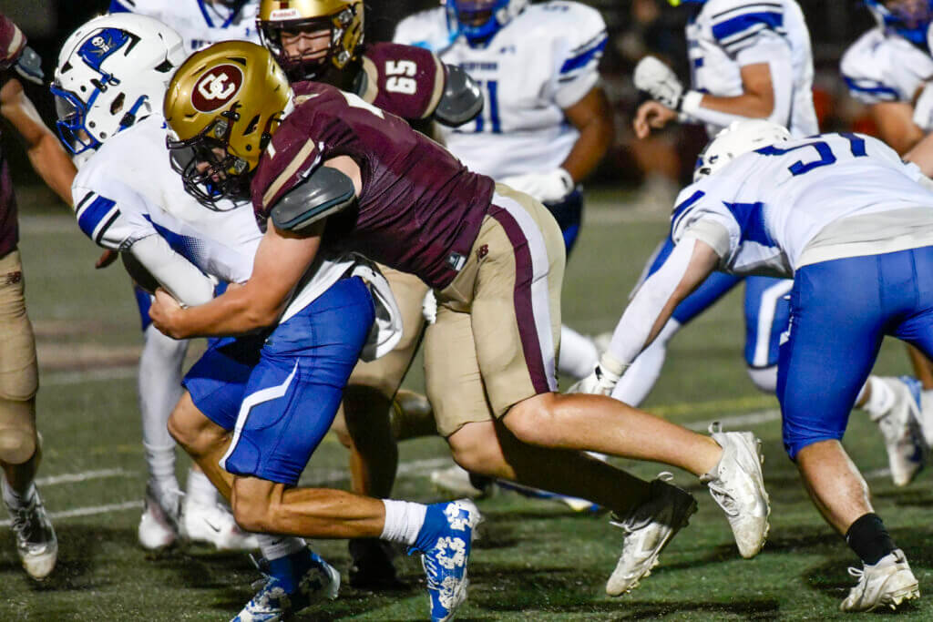 The Patriots’ James Jenney makes a tackle on the defensive line against Bedford on October 2. Photo by Cris Van Dyke