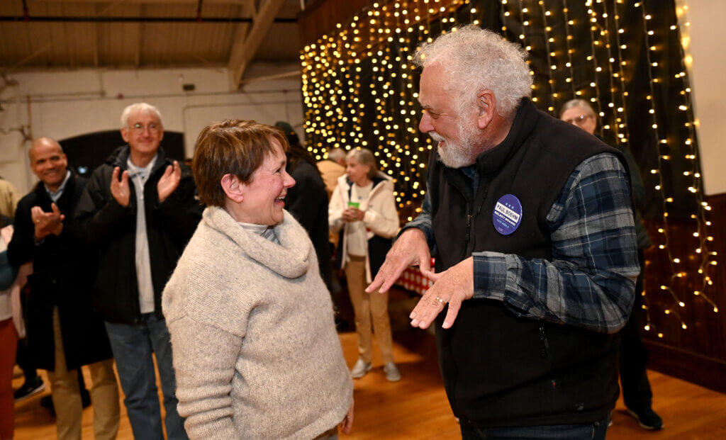 Select Board winners Mary Hartman, left, and Paul Boehm discuss the good news during a an election night unity rally at the Acton Armory on Tuesday, April 8, 2025. Ken McGagh/The Acton Bridge