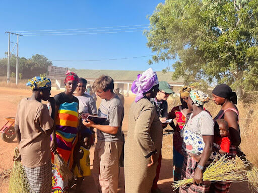 Peace Corps volunteer Mikaela Smith checks in community women volunteering for a community cleanup exercise, with help from fellow volunteer Conor Kelly. Photo by Isatou Jobe