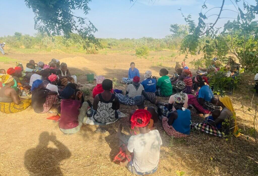 At the Farmer Field School in the garden, Peace Corps volunteer Mikaela Smith and local women discuss using compost versus chemical fertilizers. Photo by Yaya Bojang