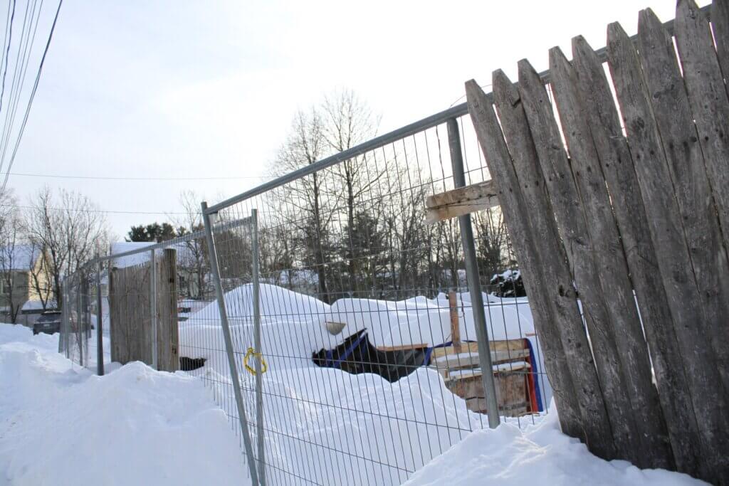 Firefighters broke through a wood fence around 36 Cottage Lane as it burned last year. As Allam rebuilds, pieces of the fence still stand near the property line. Photo: Dakota Antelman/The Acton Bridge