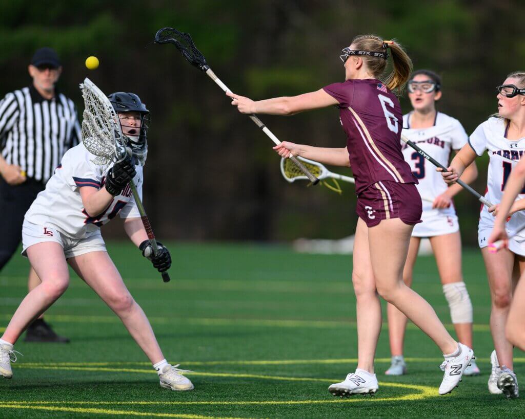 Patriots attacker Scarlett Mirak (No. 6) scores one of her three goals on the day in the nailbiter win over Lincoln-Sudbury that kept the Patriots undefeated on the season. Photo by Jon Straggas