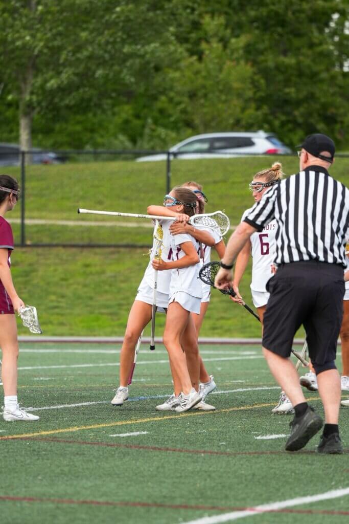 Lindsay Cain (back) hugs Maisie Martinez (No. 2) after a Patriots goal. Photo by Aidan Moroney