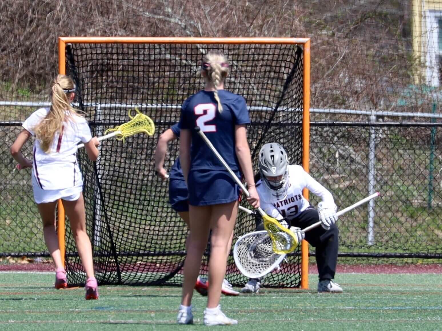 Mamie Kosicki (No. 13) goes low for the save during the April 23 win over Central Catholic. Photo by Jason Fortier