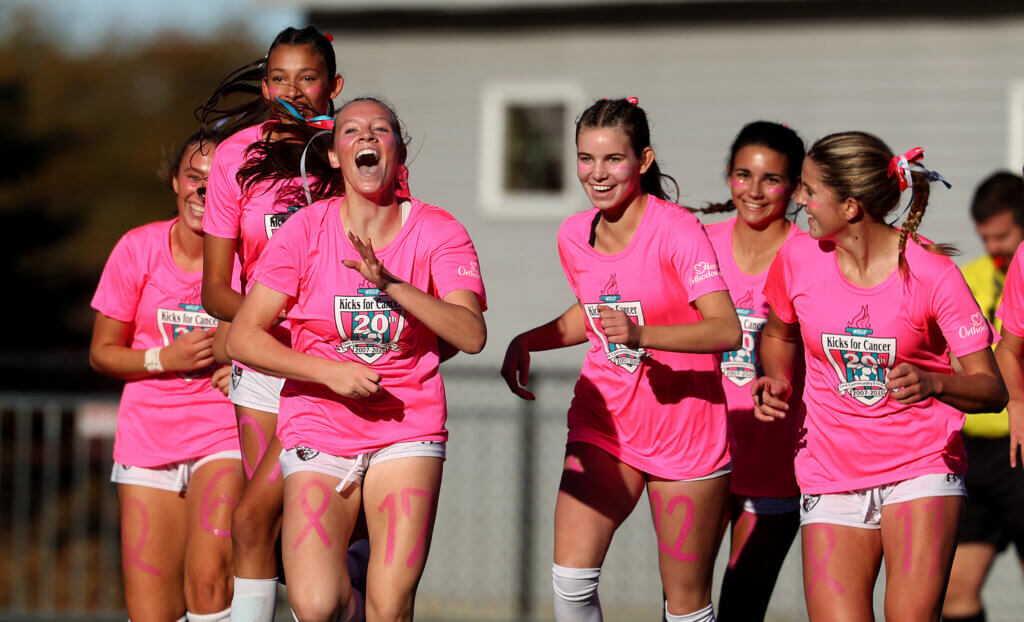 Caroline Ferrari, front left, and teammates rejoice after Ferrari scored the Patriots’ first goal of the game.