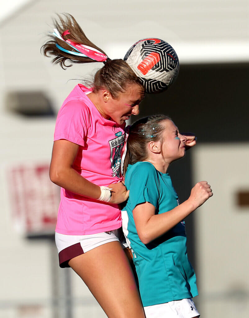 Camy Cox, left, heads the ball.