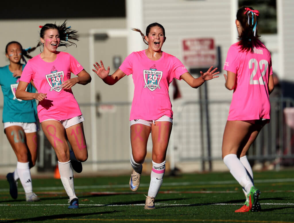 Co-captain Emmy O’Donnell, center, is flanked by teammates Paige Taunton-Rigby, left, and Annie Beal, right, after scoring a first-half goal to put the Patriots up 2-0.