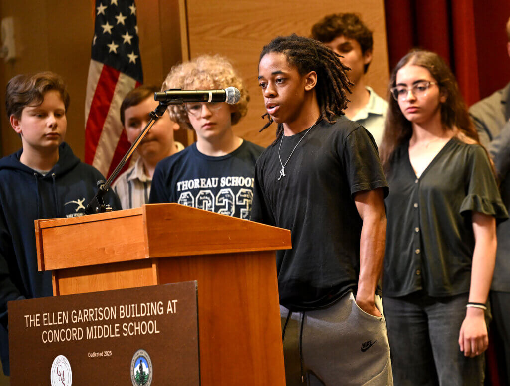 Acton eighth grader Ayden Henry of the Student Building Committee speaks during a program in celebration of the new Ellen Garrison Building at Acton Middle School on Wednesday, June 11, 2025. Behind him are other student members of the committee. Ken McGagh/The Acton Bridge