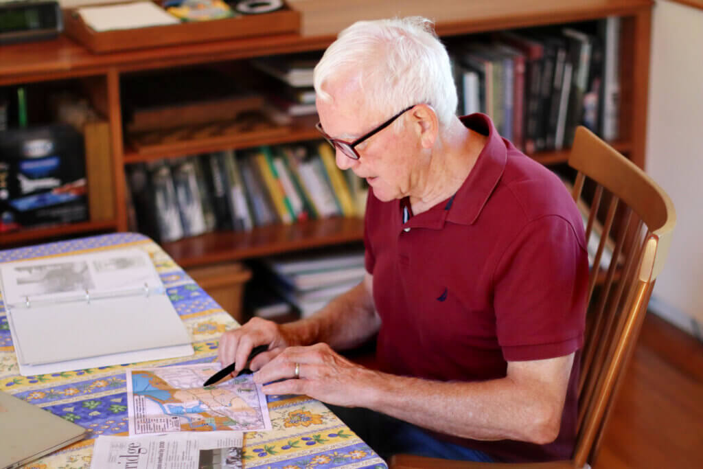 Bill Robichaud keeps maps and records of trails, including old brochures from the Trails Committee. Photo: Trace Salzbrenner/The Acton Bridge
