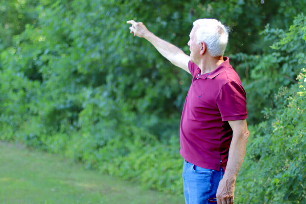 Bill Robichaud points toward the Reformatory Branch Trail, which sits a half-mile from his front door. Photo: Trace Salzbrenner/The Acton Bridge