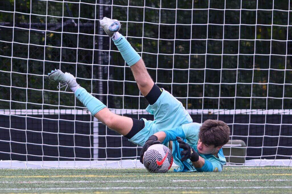 Goalkeeper Max Furman makes a save late in the second half against Cambridge Rindge & Latin on September 16. Photo by Jon Straggas