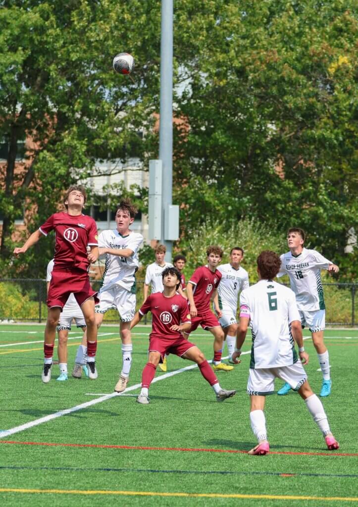 Ben Hackman (No. 11) and Adrian Avini (No. 16) vie for position against the visitors from Bishop Feehan. Photo by Rebecca Woodward