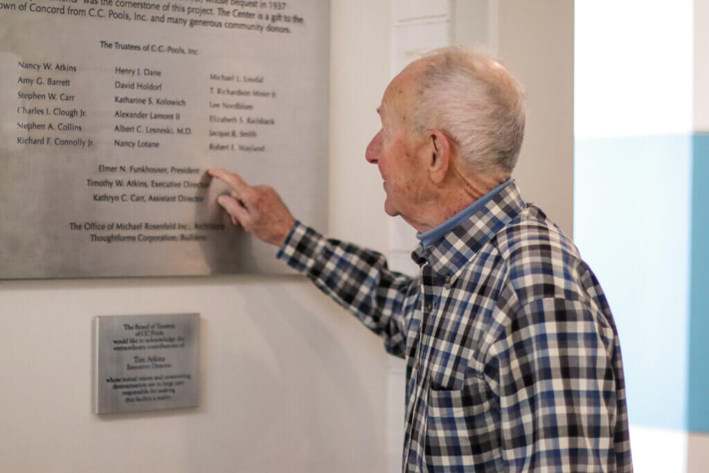 Funkhouser points out his name on a plaque in the Beede Swim and Fitness Center. Photo: Trace Salzbrenner/Acton Bridge