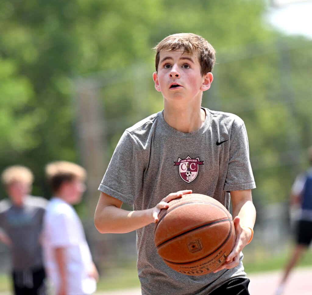 Ewan van der Swaagh, 15, a rising freshman at Acton-Carlisle High School, lines up a shot during a one-day 3v3 basketball tournament to raise money and awareness for NMDP, formerly known as the National Marrow Donor Program, a non-profit that manages a global bone marrow registry that finds donors for lifesaving bone marrow transplants, at Emerson Playground on Saturday, July 26, 2025. At age five, Ewan was diagnosed with a rare form of leukemia. He has received two bone barrow transplants through the NMDP registry and has been remission for seven years. Ewan’s team, the John Pork Elite almost won the championship, finishing second to the Corn of the Cobbe team. $3,100 was raised Saturday. Ken McGagh/The Acton Bridge
