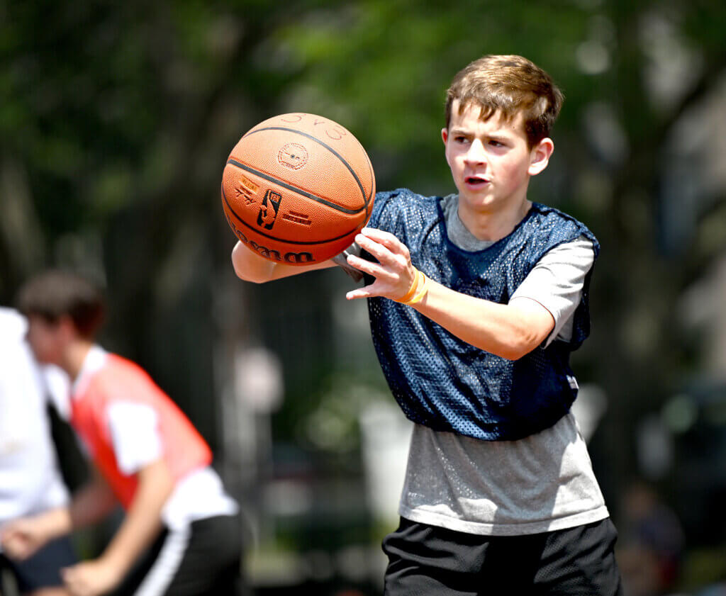 Ewan van der Swaagh, 15, a rising freshman at Acton-Carlisle High School, passes the ball during a one-day 3v3 basketball tournament to raise money and awareness for NMDP, formerly known as the National Marrow Donor Program, a non-profit that manages a global bone marrow registry that finds donors for lifesaving bone marrow transplants, at Emerson Playground on Saturday, July 26, 2025. At age five, Ewan was diagnosed with a rare form of leukemia. He has received two bone barrow transplants through the NMDP registry and has been remission for seven years. Ewan’s team, the John Pork Elite almost won the championship, finishing second to the Corn of the Cobbe team. $3,100 was raised Saturday. Ken McGagh/The Acton Bridge