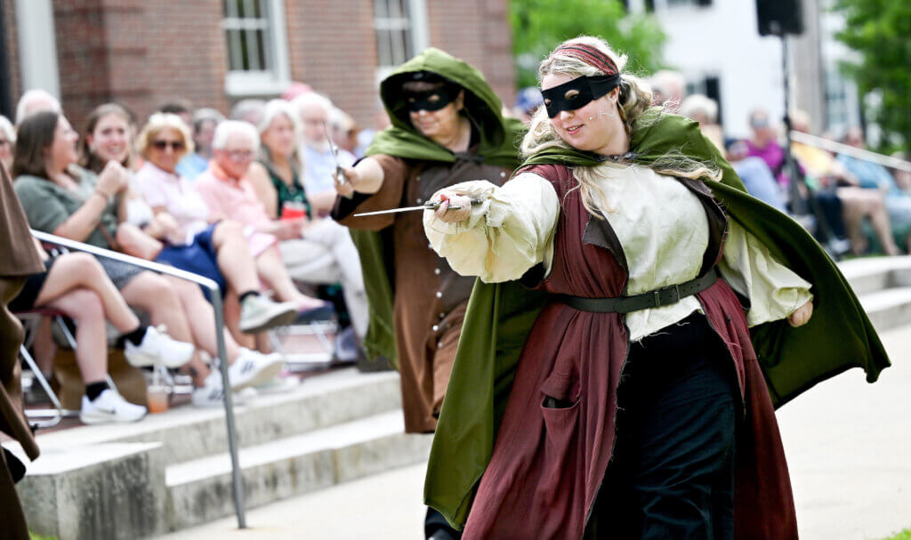 Hannah Clifford, as Peto does battle on the Acton Free Public Library lawn during The World’s A Stage Players production of William Shakespeare’s “Henry IV, Part I” on on Saturday, July 26, 2025. Two more outdoor performances are scheduled for August 2 and 3 at the library. Ken McGagh/The Acton Bridge