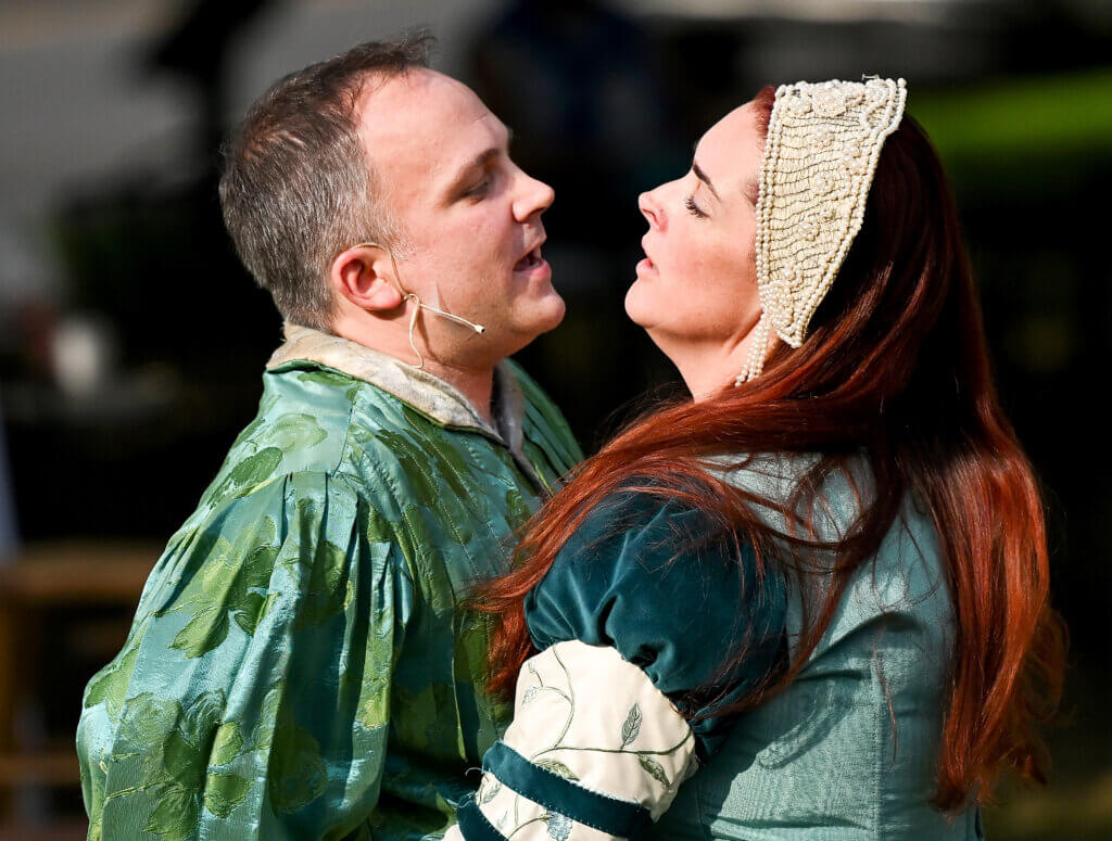 Nicholas Meunier, as Henry “Hotspur” Percy and Savanah Carlson as Lady Percy act in a scene from William Shakespeare’s “Henry IV, Part I” on the Acton Free Public Library lawn on Saturday, July 26, 2025. Two more outdoor performances are scheduled for August 2 and 3 at the library. Ken McGagh/The Acton Bridge
