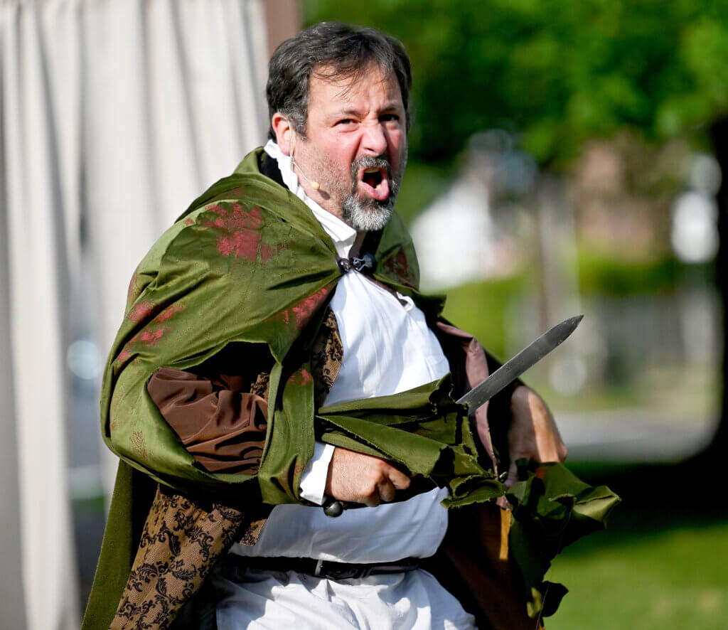 Mike Haddad, as Sir John Falstaff, during The World’s A Stage Players production of William Shakespeare’s “Henry IV, Part I” on the Acton Free Public Library lawn on Saturday, July 26, 2025. Haddad is also the show’s director. Ken McGagh/The Acton Bridge