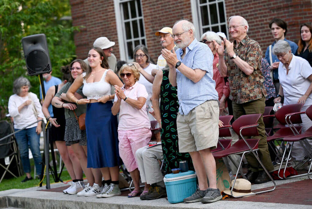 The audience rises for a standing ovation as The World’s A Stage Players actors take a curtain call after a production of William Shakespeare’s “Henry IV, Part I” on the Acton Free Public Library lawn on Saturday, July 26, 2025. Two more outdoor performances are scheduled for August 2 and 3 at the library. Ken McGagh/The Acton Bridge