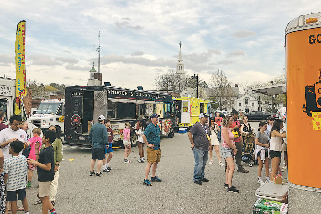 Concord250 attendees line up outside food trucks in the Walden Street municipal parking lot. Photo: Dakota Antelman/The Acton Bridge