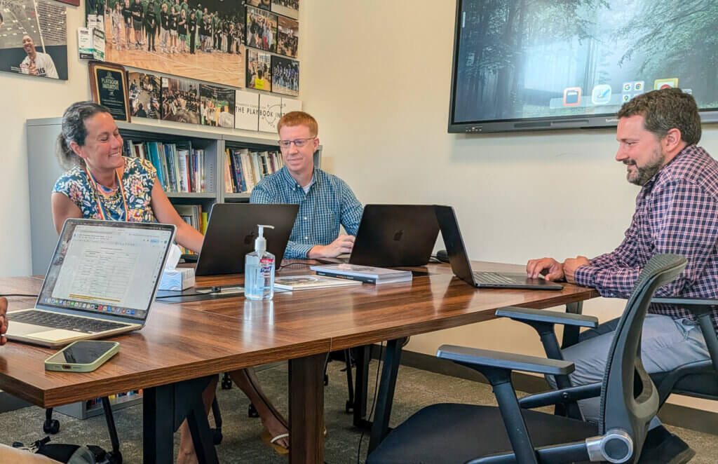 Justin Cameron, center, holds a meeting in his office with Assistant Principal Olive Bradford, left, and incoming interim Principal Dan Hausermann, right. Photo: Trace Salzbrenner/The Acton Bridge