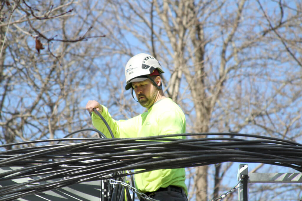 A worker wrangles cables while crews set up temporary cell towers in Acton Center on March 14. Photo: Dakota Antelman/The Acton Bridge