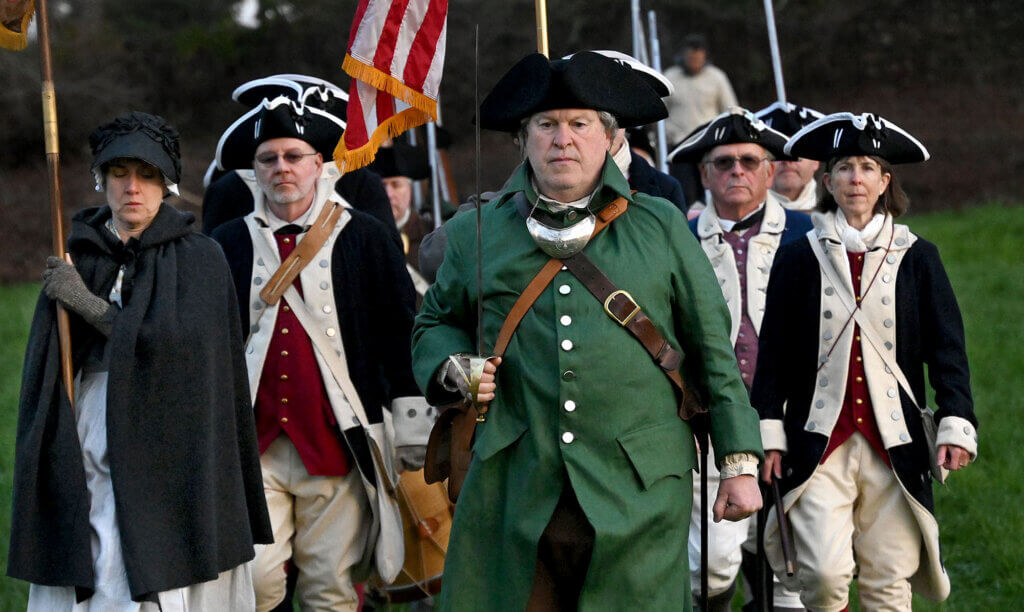 Carl Sweeney, captain of the Acton Minute Men, leads his militia over the Old North Bridge.