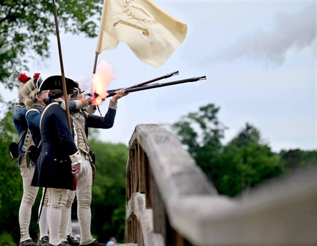 The 10th Massachusetts Regiment fires a musket volley from North Bridge.