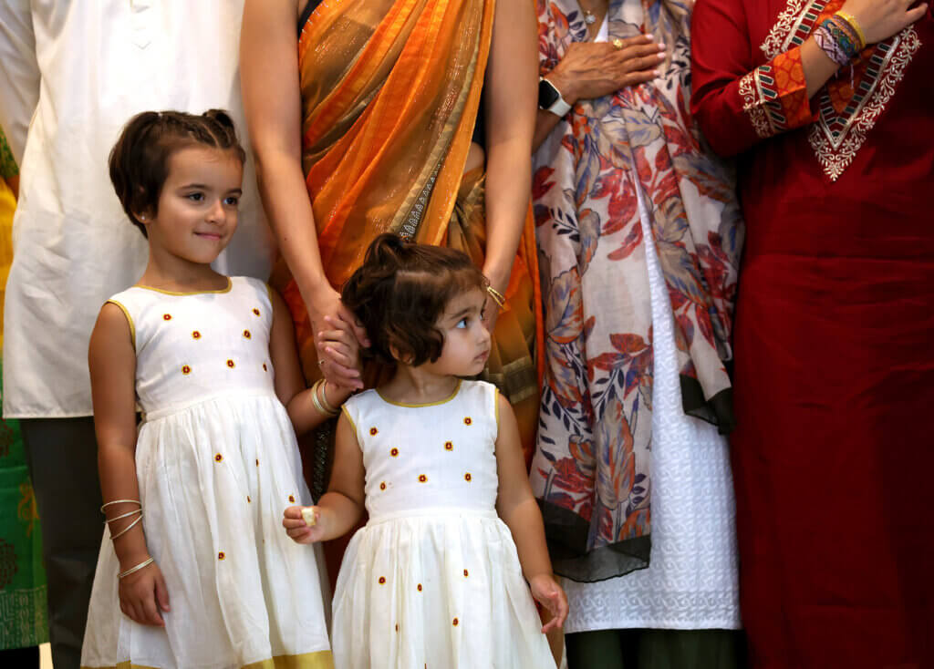 Arya Cratsley, 5, of Acton, and her sister Simi, 2, join the adults on stage for the playing of the national anthem during Acton's second annual India Day celebration at First Parish on August 16, 2025. Both the American and Indian national anthems were played Saturday.